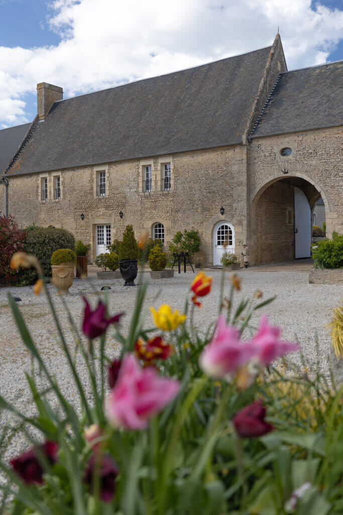 Cour intérieure fleurie de l'hôtel de charme La Ferme de la Ranconniere en Normandie