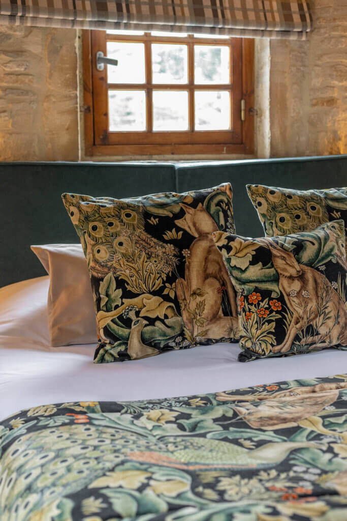 Détails des coussins décoratifs sur le lit de la chambre Donjon de La Rançonnière