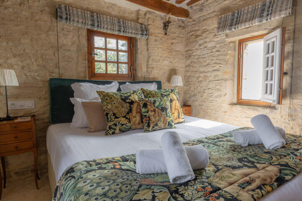 Chambre Donjon de La Rançonnière avec lit double et murs en pierre apparente