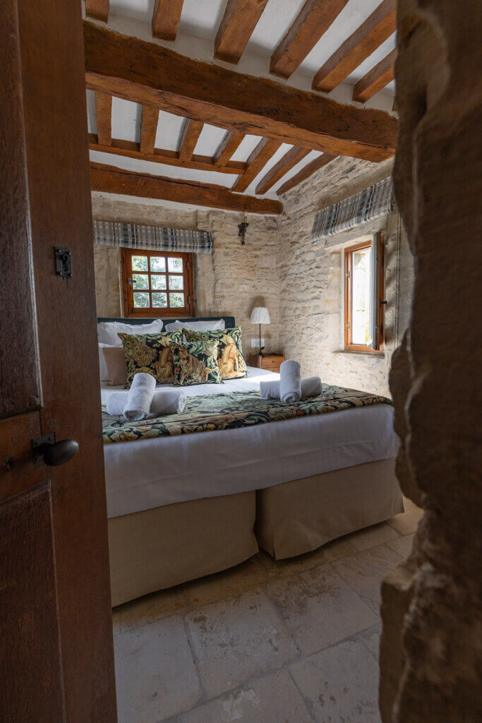 Chambre Donjon de La Rançonnière avec lit double et poutres apparentes