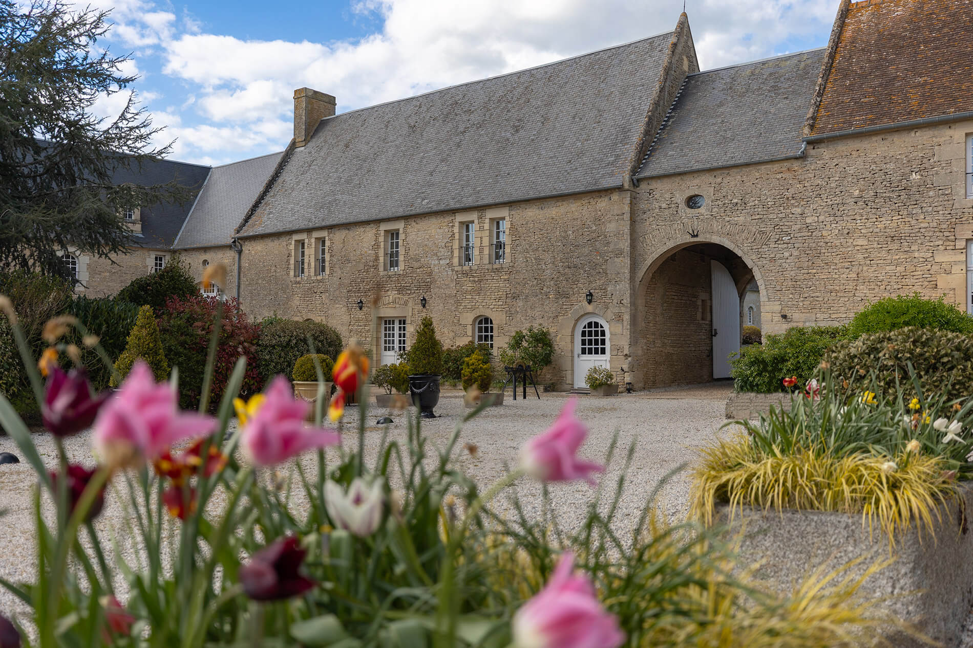 Cour intérieure fleurie de l'hôtel de charme La Ferme de la Ranconniere en Normandie