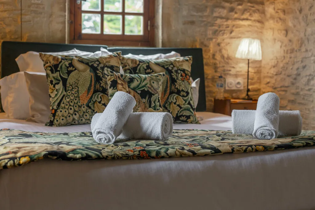 Serviette sur le lit de chambre de luxe de l'hotel Ferme de la Ranconniere en Normandie